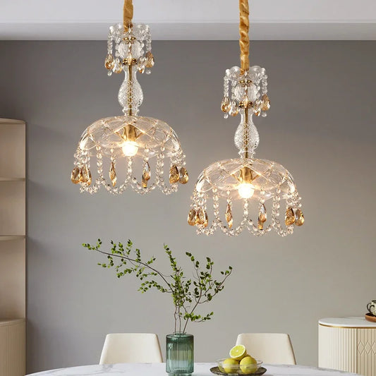LED Crystal Chandelier Art Deco pendant lights with gold accents hanging over a dining table, ideal for elegant home lighting décor.