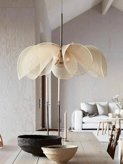 Bubble glass chandelier - modern nordic pendant light with petal-shaped fabric shade, hanging above a rustic dining table in a minimalist interior.