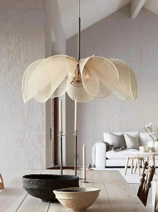 Bubble glass chandelier - modern nordic pendant light with petal-shaped fabric shade, hanging above a rustic dining table in a minimalist interior.
