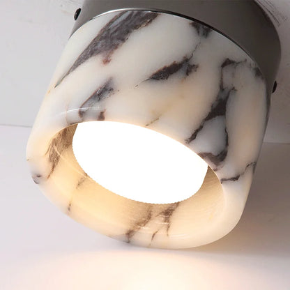 Illuminated Nordic LED wall sconce with warm light glowing through marble-effect glass, ideal for ambient hallway lighting.