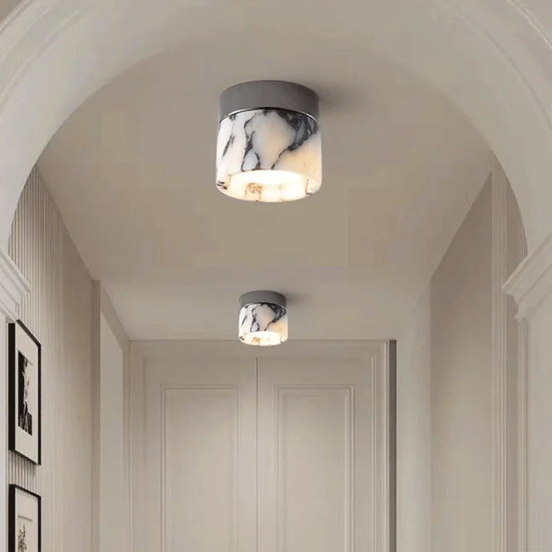 Pair of Nordic LED wall sconces installed in a hallway, showcasing modern glass and stone design for stylish ambient lighting.