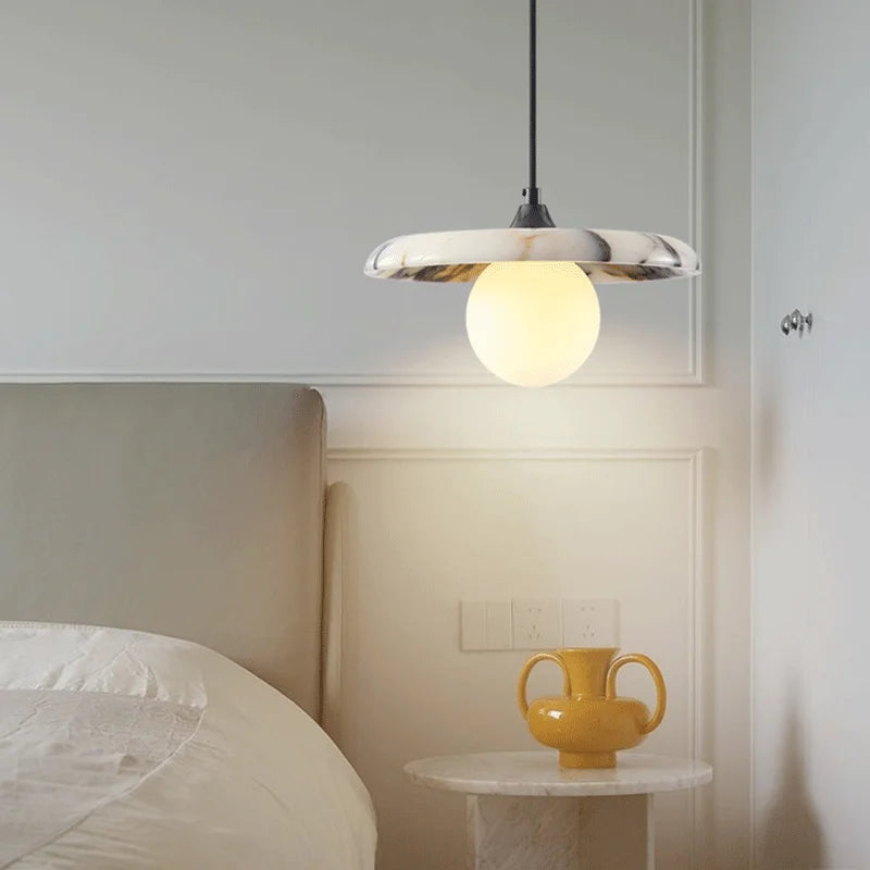 Black LED Marble Pendant Light hanging beside a bed, offering ambient lighting and a sleek modern touch to bedroom interiors.