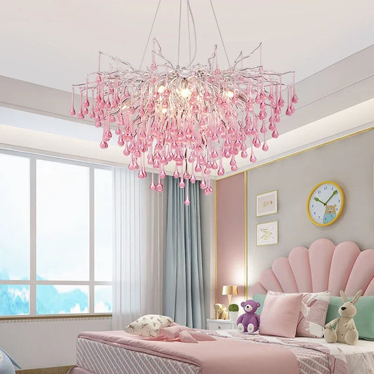 Princess pink crystal chandelier with LED lights hanging in a pastel-themed bedroom. Modern design with teardrop crystals, ideal for kids' rooms.