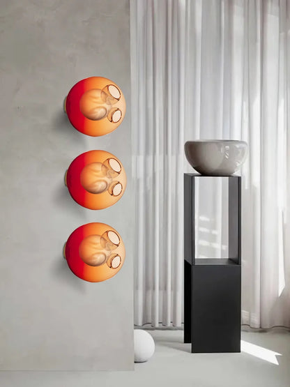 Gradient red Italian designer glass wall sconces in a modern interior, adding vibrant LED lighting to bedroom or café spaces.