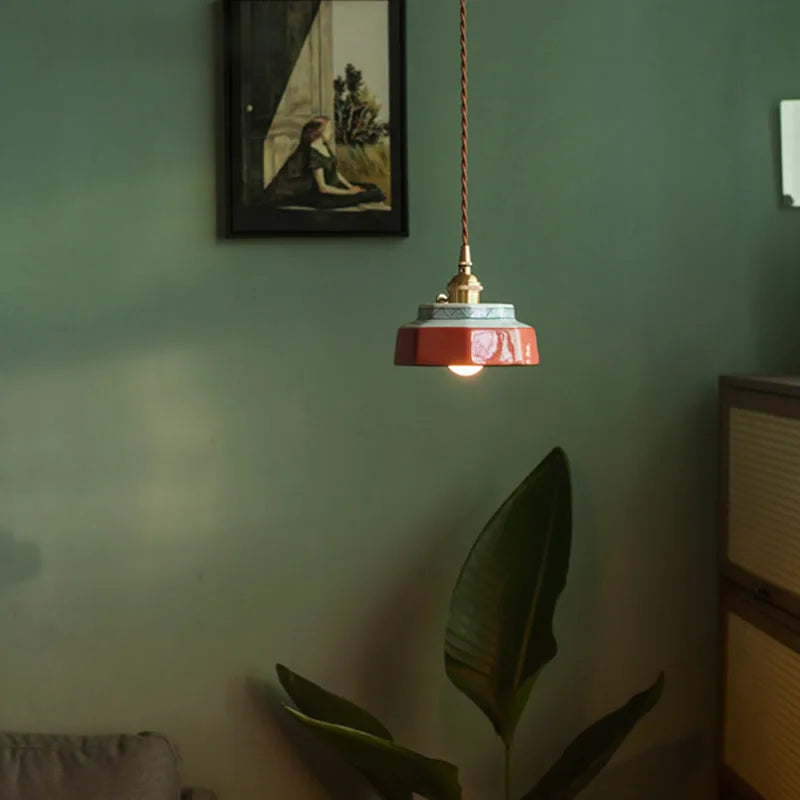 Modern LED ceramic pendant lamp with copper accents hanging in a cozy living room, ideal for stylish home lighting decor.