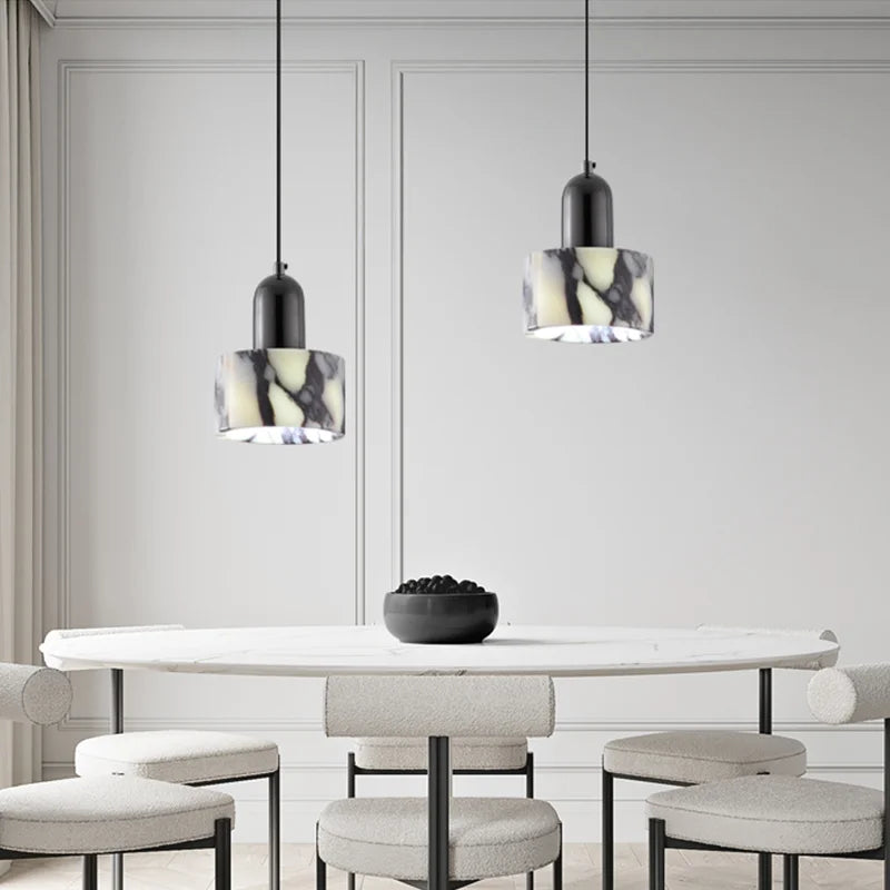 Two Black Marble Pendant Lights with Nordic LED design hanging above a round dining table, enhancing minimalist decor.