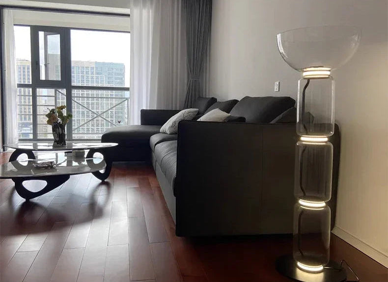 Italian minimalist glass floor lamp – nordic design with LED-lit stacked glass, complementing a modern living room setup.
