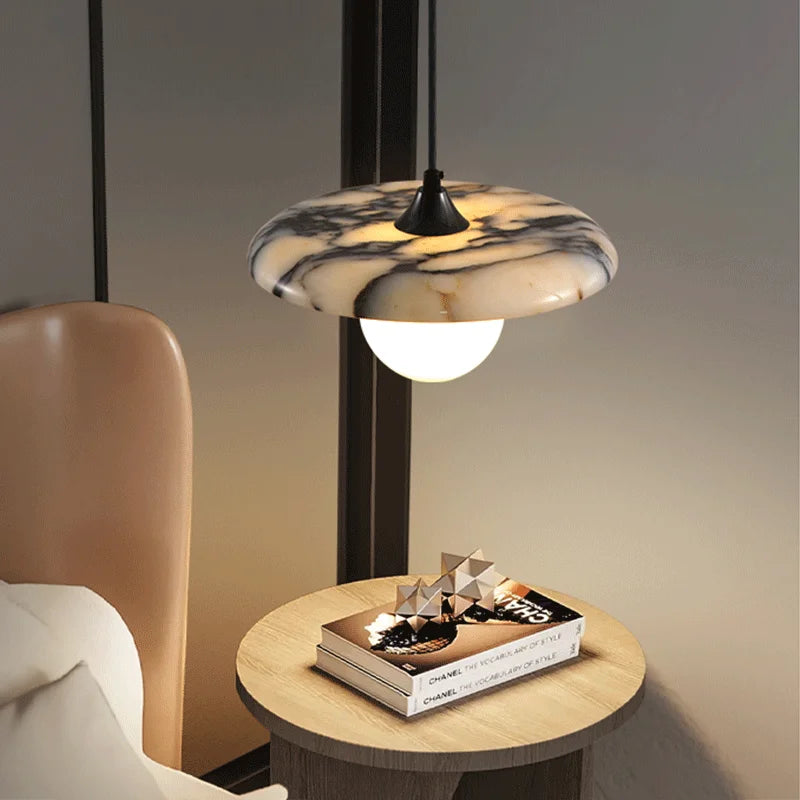 Modern Marble Pendant Light with black LED chandelier above a nightstand, blending luxury materials with soft lighting for cozy interiors.