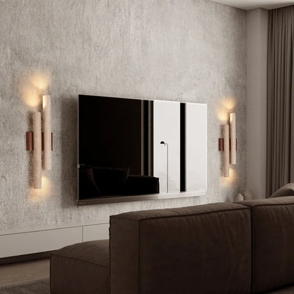 Pair of travertine stone bedroom wall lamps with wood accents flanking a TV, providing soft ambient lighting in a contemporary living room.