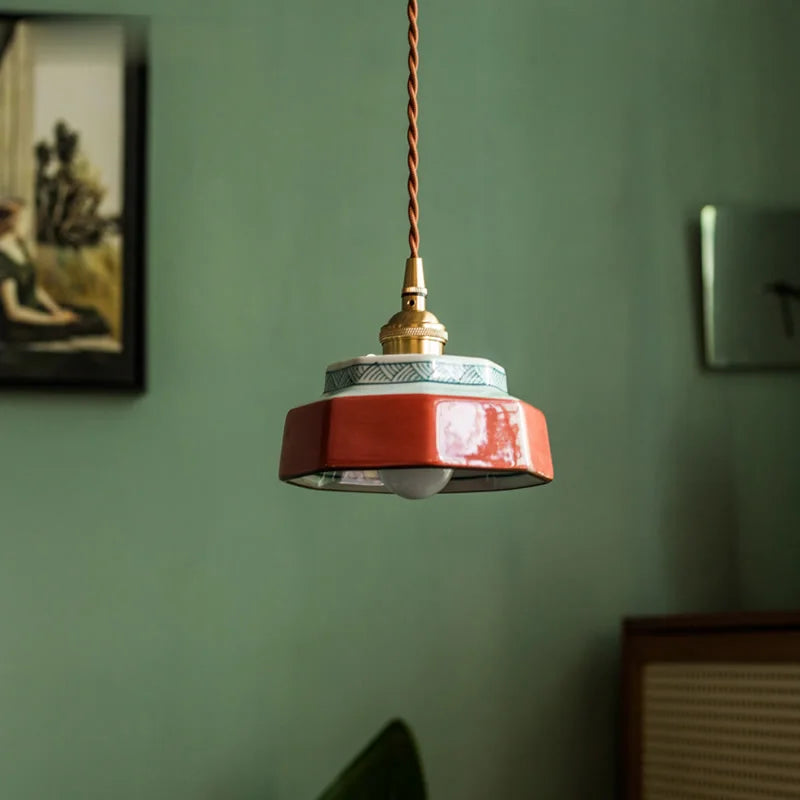 Hand-painted ceramic LED pendant light with copper fixture, suspended in a minimalist interior for ambient room lighting.