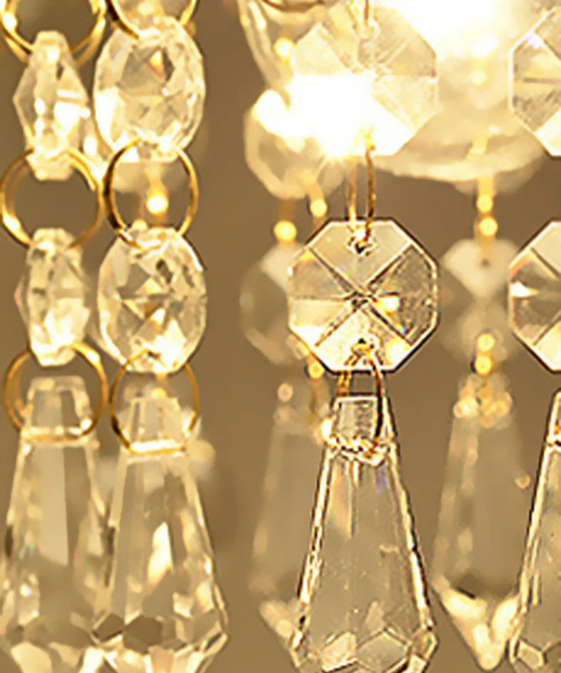 Macro shot of gold crystal chandelier lighting highlighting faceted crystal drops and golden rings for a royal vintage look.