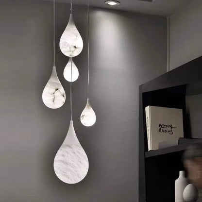 Teardrop-shaped marble LED pendant lights hanging in a modern room. Marble LED pendant light – modern ceiling lamp dimmable for ambient lighting.