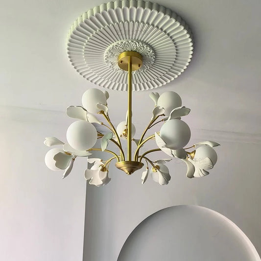 Modern dining pendant light fixture with gold frame and white floral glass shades, mounted on a decorative ceiling medallion.