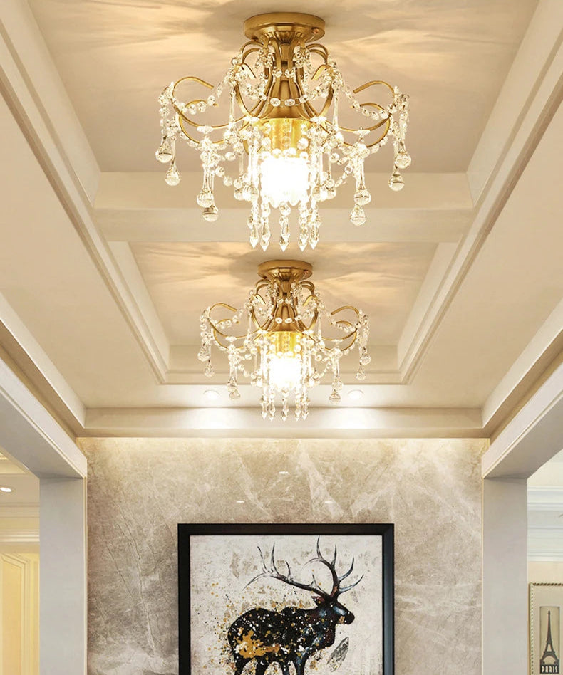 Elegant gold crystal chandelier lighting installed in a hallway, enhancing hotel or villa interiors with vintage royal charm.