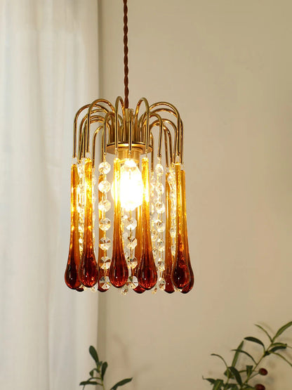 Illuminated vintage copper pendant light with glowing amber glass drops, ideal for bedroom or bay window ambiance.