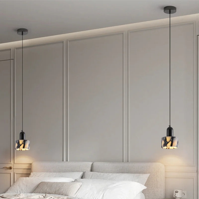 Pair of Black Marble Pendant Lights with Nordic LED above a bed, offering symmetrical and modern bedroom illumination.