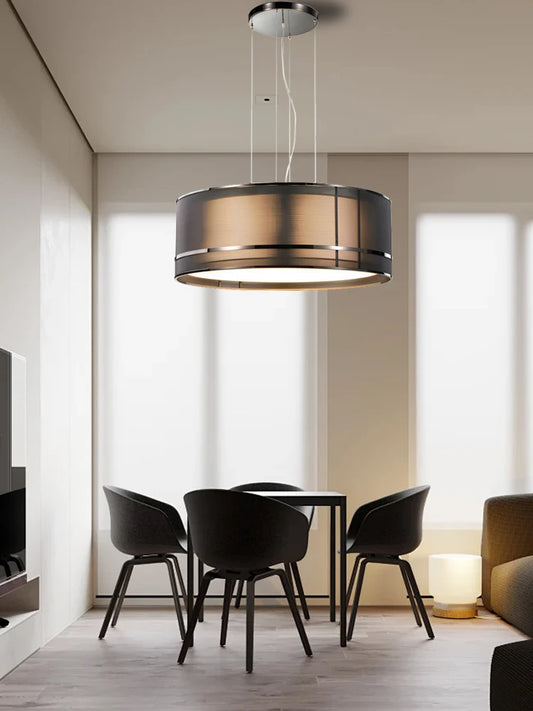 Modern ceiling chandelier in Italian designer style hanging above a minimalist dining table with black chairs in a bright living space.