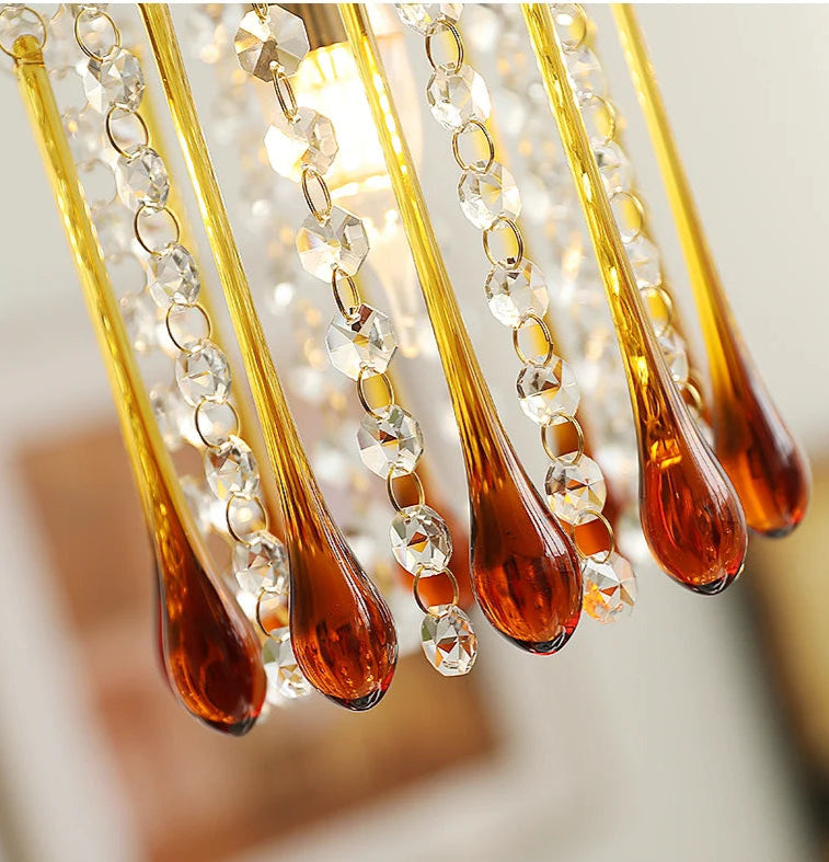 Detailed view of amber water drop glass and crystal strands on vintage copper chandelier, highlighting craftsmanship.