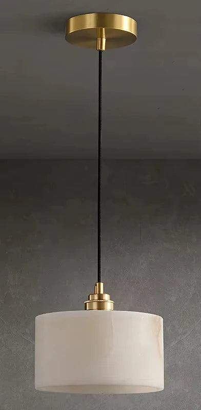 Comparison of marble pendant light turned off and on, highlighting warm LED glow and elegant brass detailing.