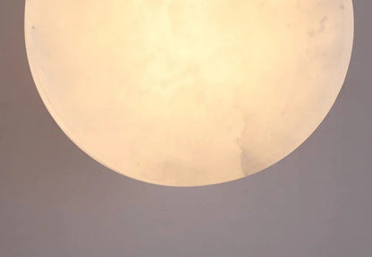 Zoomed-in view of illuminated marble shade on Modern LED Wall Lamp, highlighting its warm glow and stone pattern.