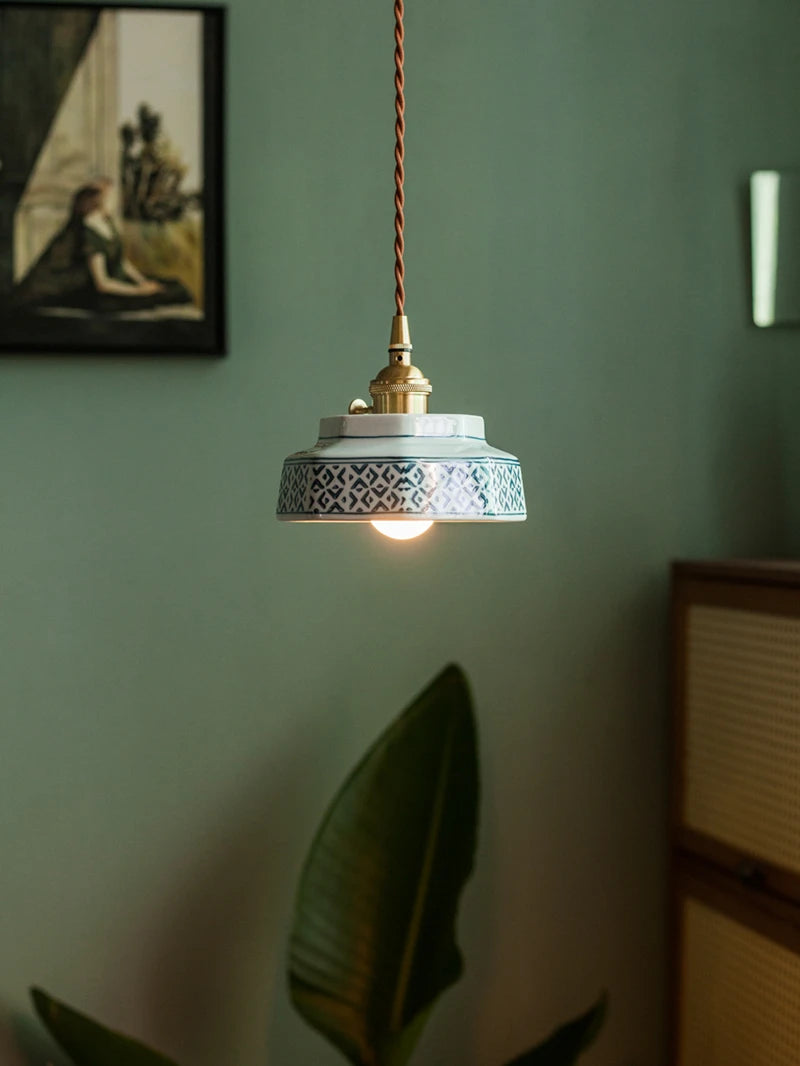 LED ceramic pendant lamp with blue geometric design and copper fixture, enhancing a modern home lighting setup.