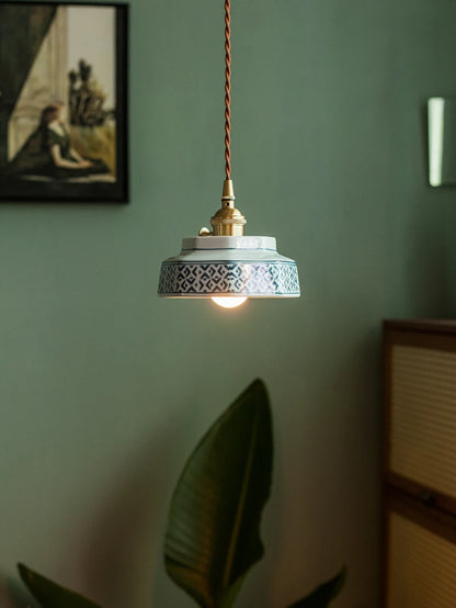 LED ceramic pendant lamp with blue geometric design and copper fixture, enhancing a modern home lighting setup.