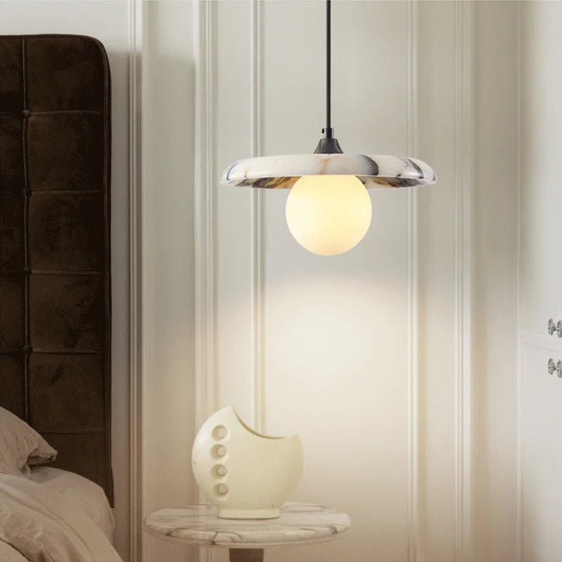 Black LED Marble Pendant Light in a minimalist bedroom, suspended above a marble side table for a stylish and functional lighting solution.