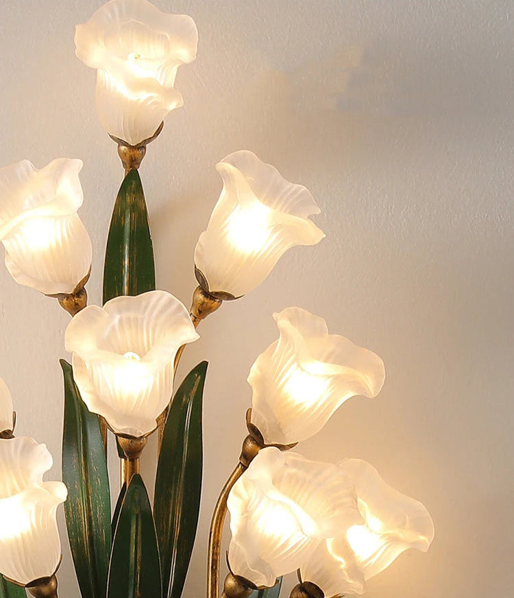 Close-up of white flower glass shades on French wall sconce, highlighting soft lighting and vintage floral design.