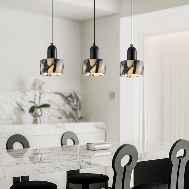 Three Black Marble Pendant Lights with Nordic LED style suspended above a marble kitchen island, creating a luxurious modern look.