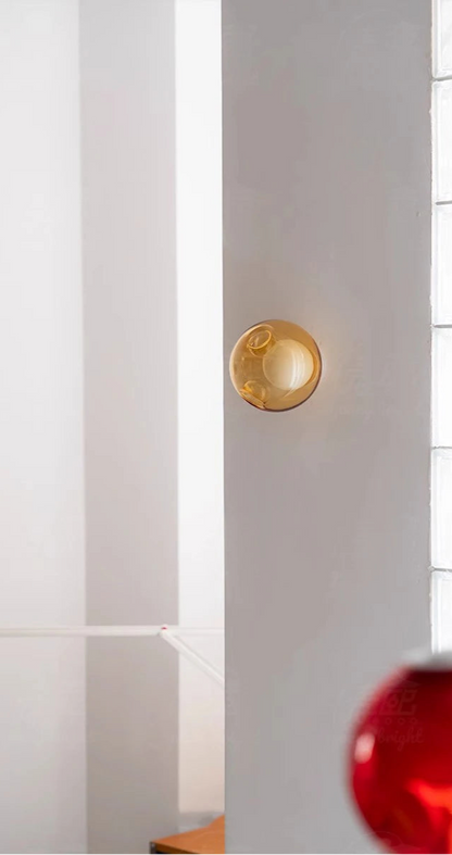 Amber Italian designer glass wall sconce on a white wall, ideal for soft LED lighting in contemporary bedroom or café settings.