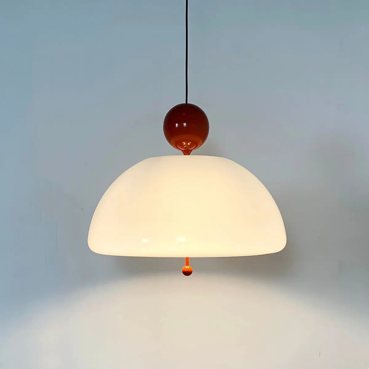 Warm-lit Vintage Glass Pendant Light with red spherical top, blending medieval charm with contemporary lighting design.