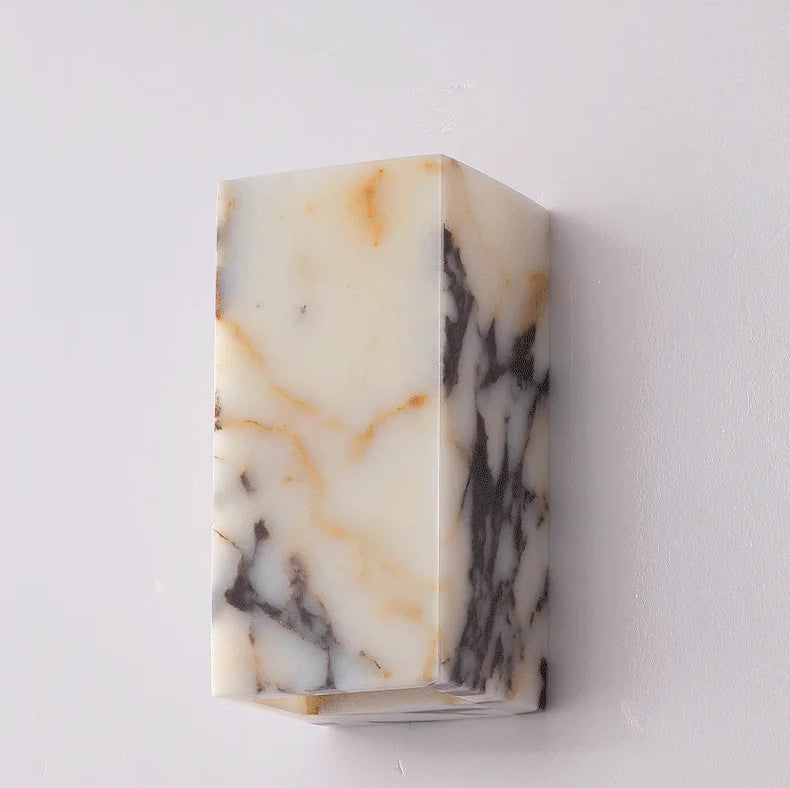 Comparison of black marble wall sconce turned off and on, showcasing warm LED lighting effect for elegant interiors.
