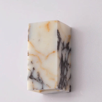 Comparison of black marble wall sconce turned off and on, showcasing warm LED lighting effect for elegant interiors.