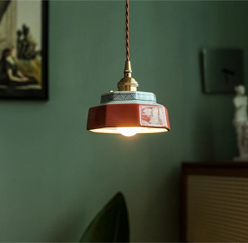 Stylish ceramic pendant light with LED bulb and copper top, perfect for modern home lighting in dining or living areas.