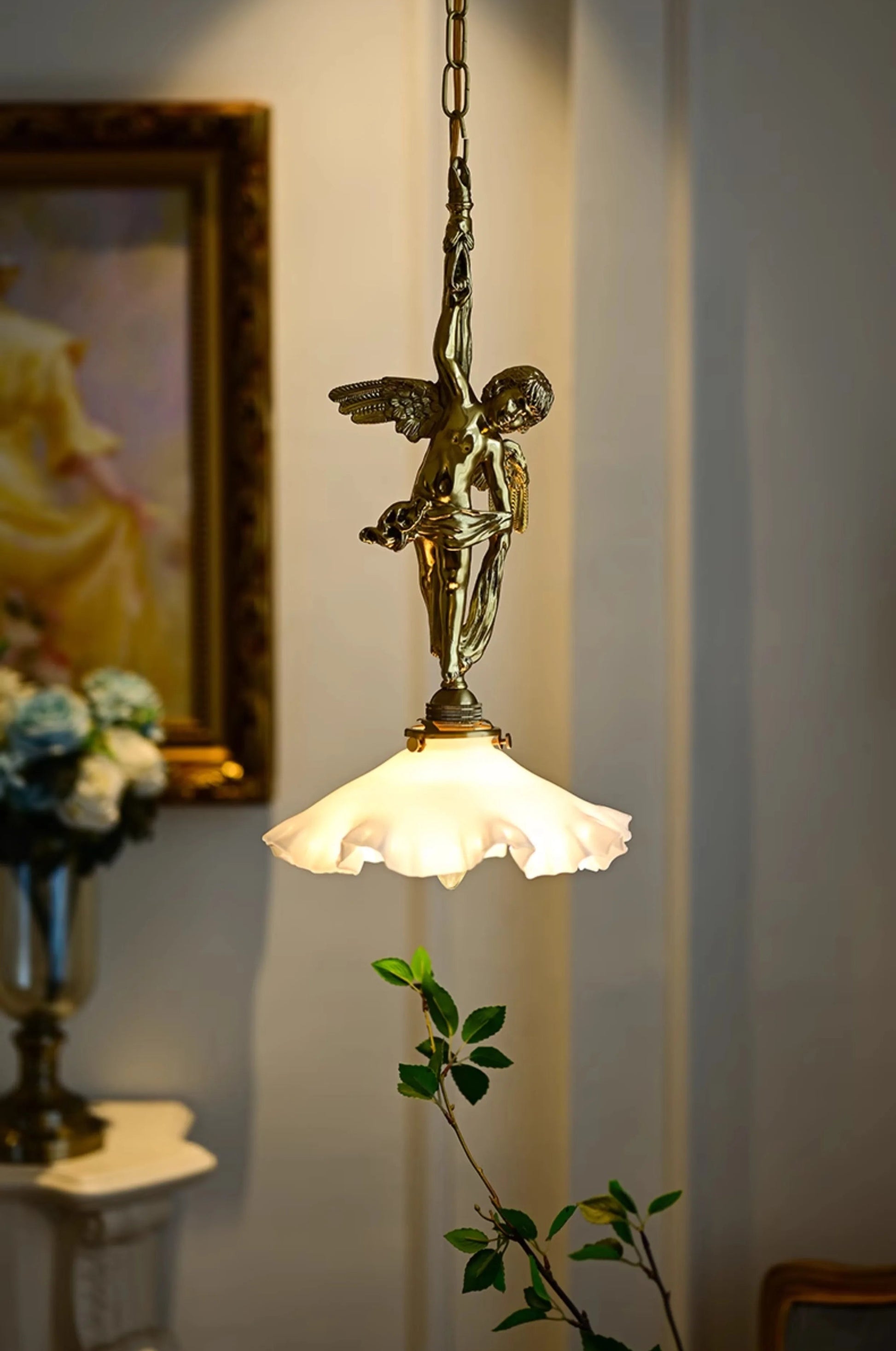 Lit Copper Angel Pendant Light with soft glow and ornate angel design, ideal chandelier for ambient dining or bedroom lighting.