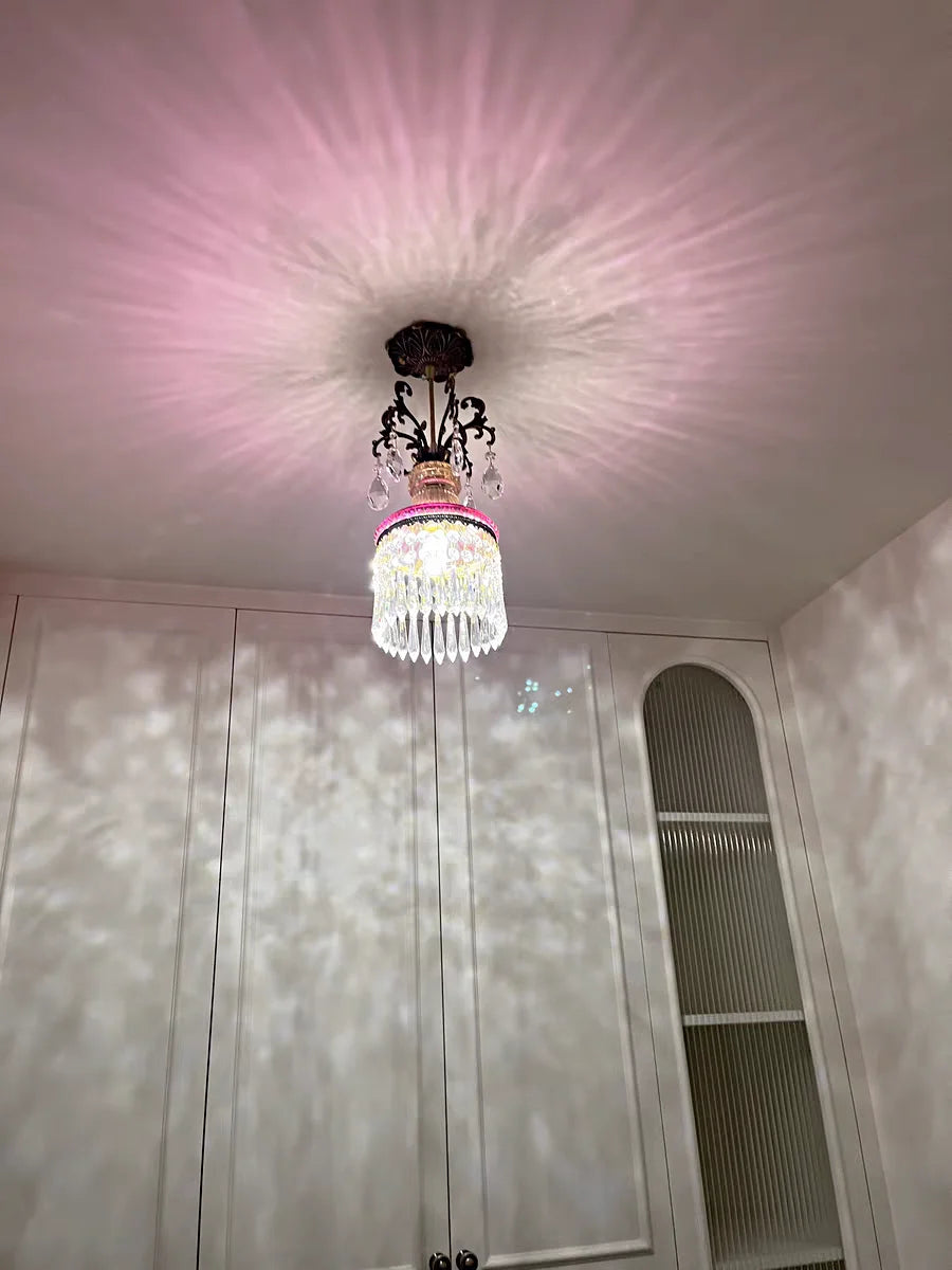 Ceiling-mounted French crystal chandelier casting radiant light patterns, luxury retro pendant for stylish bedroom lighting.