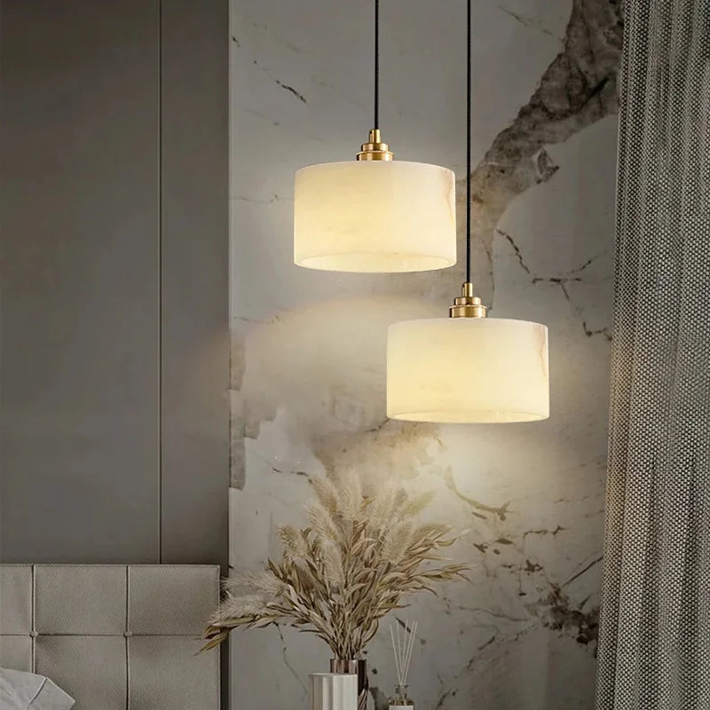 Pair of marble pendant lights hanging in a modern bedroom, ideal for luxury interior lighting in dining or hotel settings.