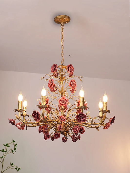 Vintage ceramic chandelier with deep pink roses and gold frame, ideal French ceiling light for restaurants or boutique clothing stores.