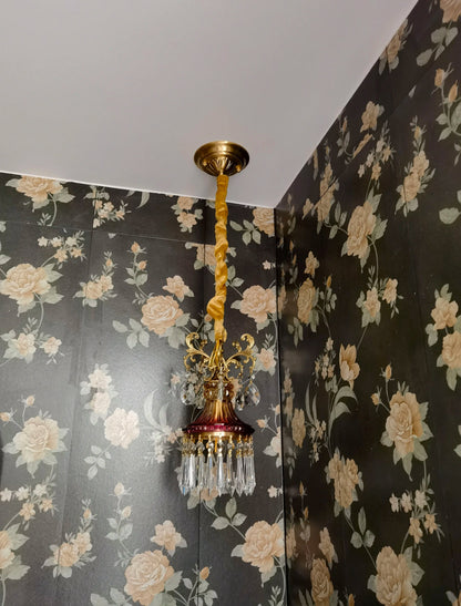 Vintage-style French crystal chandelier with twisted cord mount, luxury pendant light for floral wallpapered room.
