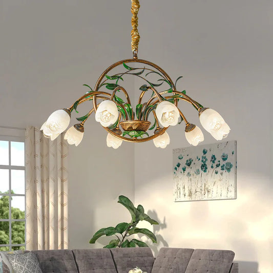 Scandinavian flower chandelier with white tulip-shaped glass shades and art deco floral frame, hanging above a modern gray sofa in a bright living room.