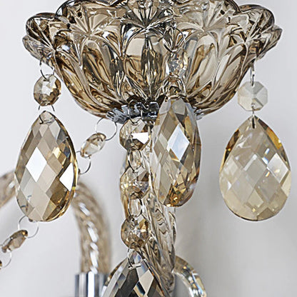 Close-up of vintage lotus-shaped crystal sconce with amber teardrop crystals, ideal for luxurious bedroom lighting.