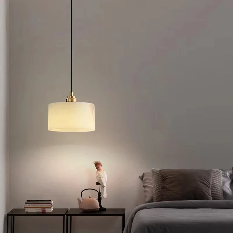 Single marble LED pendant light illuminating a bedside table, perfect for modern bedroom or dining room ambiance.