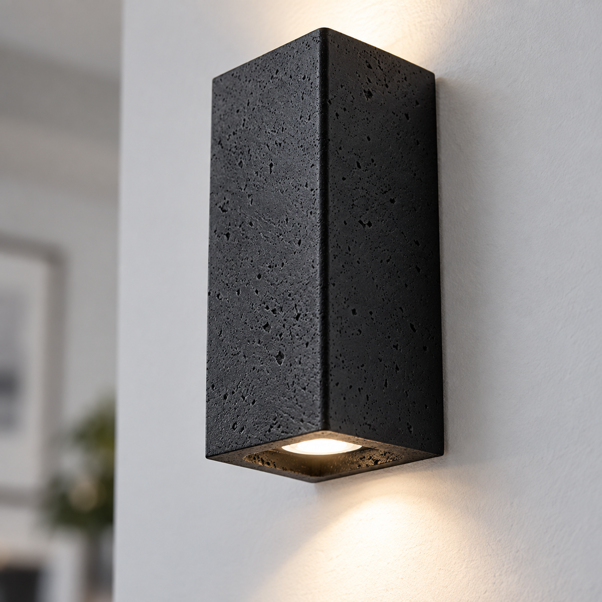 Close-up of the textured black stone and lower edge of the wall light