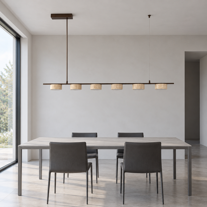 Six-shade beige stone pendant installed above an empty gray dining table in neutral daylight