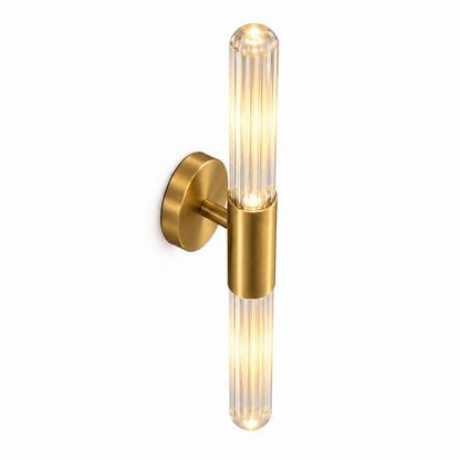 Clear fluted glass and gold wall light, illuminated, photographed from an elevated commercial angle with the upper sleeve entry and rounded glass end visible.