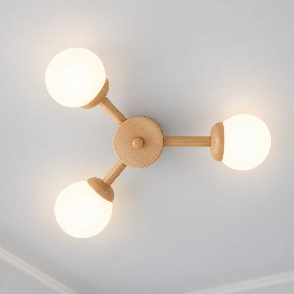 Three-globe wood ceiling light illuminated, photographed directly underneath