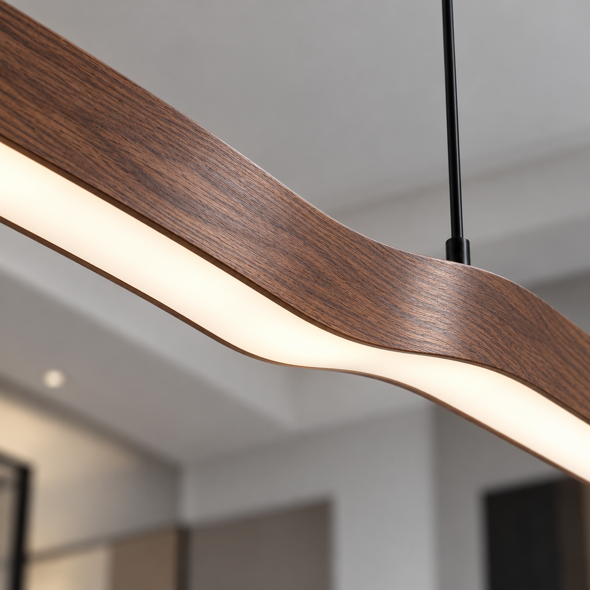 Illuminated diffuser and central curve of wood-effect wave pendant in close detail