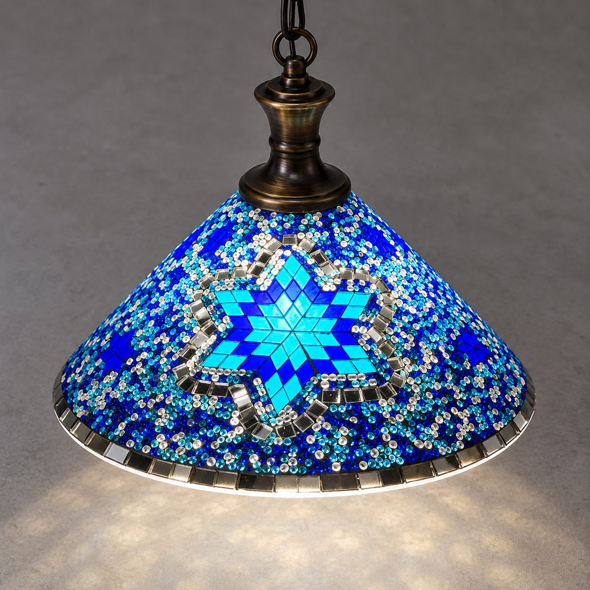 Geometric mosaic glass pendant with a wide cone shade — Style A, above style a, illuminated and faithfully mounted.