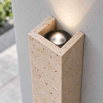 Natural travertine wall light, illuminated upper optic and stone detail from above