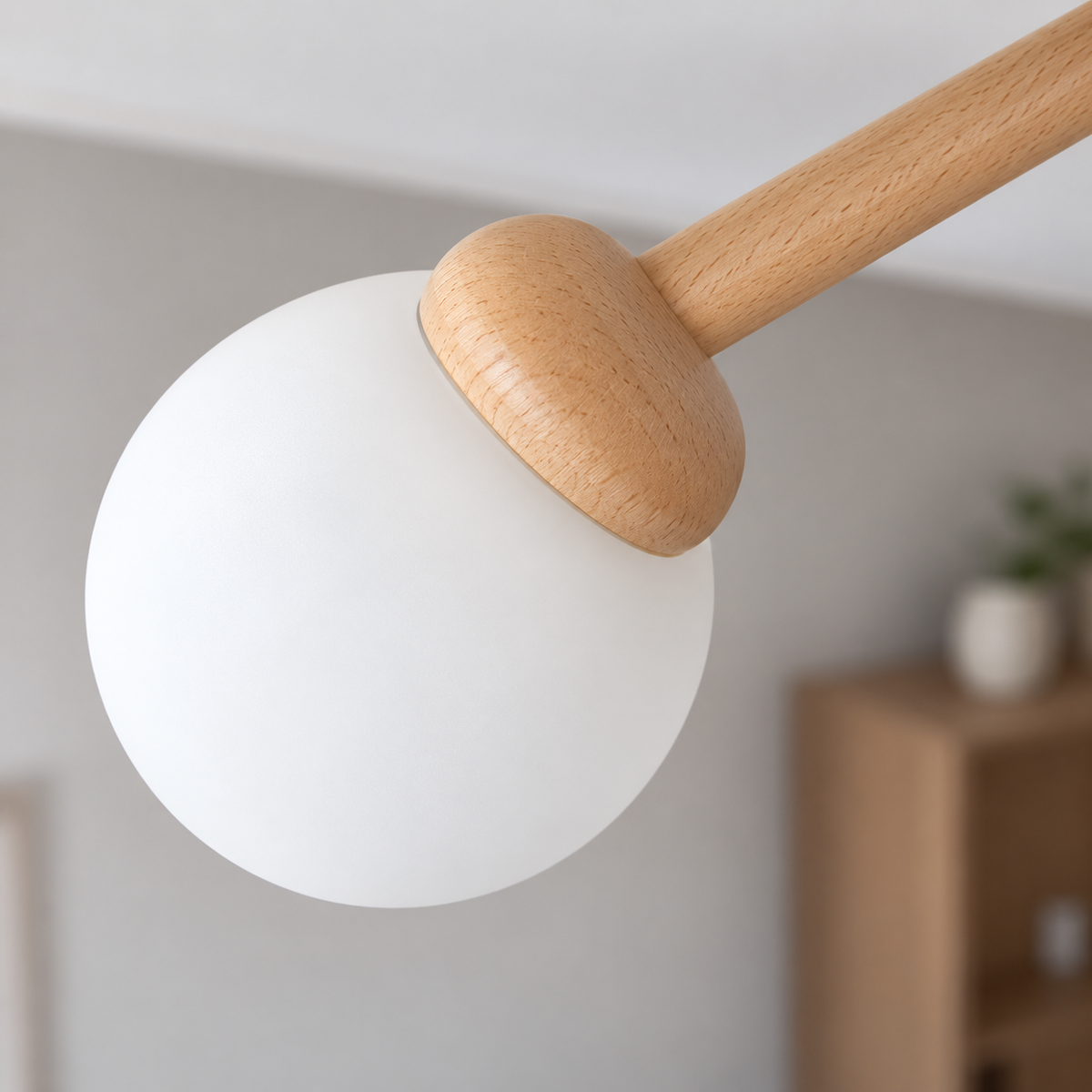 Elevated close detail of the upper frosted glass globe, wood socket and arm of the flush ceiling light